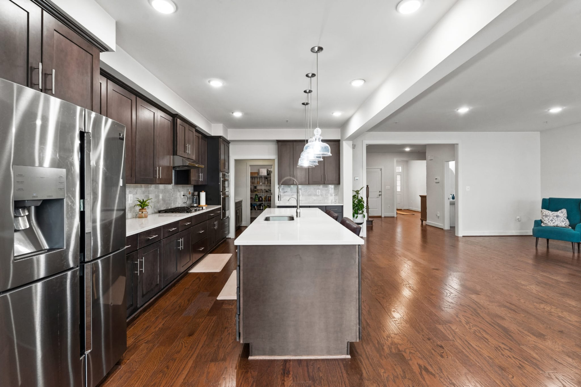 Kitchen with quartz island, pendant lighting and stainless appliances
