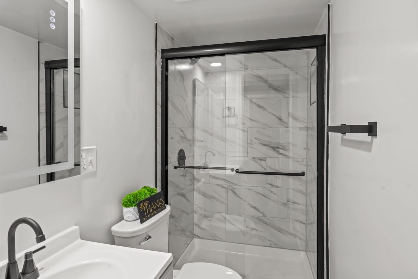 Renovated bathroom with marble tile shower and matte black hardware
