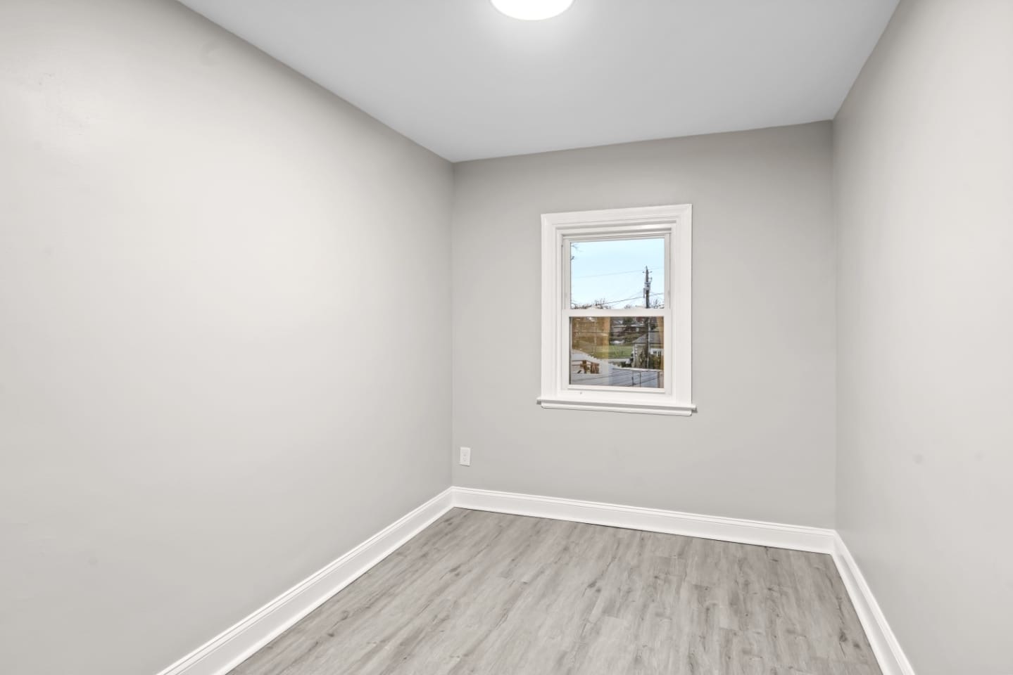 Freshly painted bedroom with luxury vinyl plank flooring and natural light