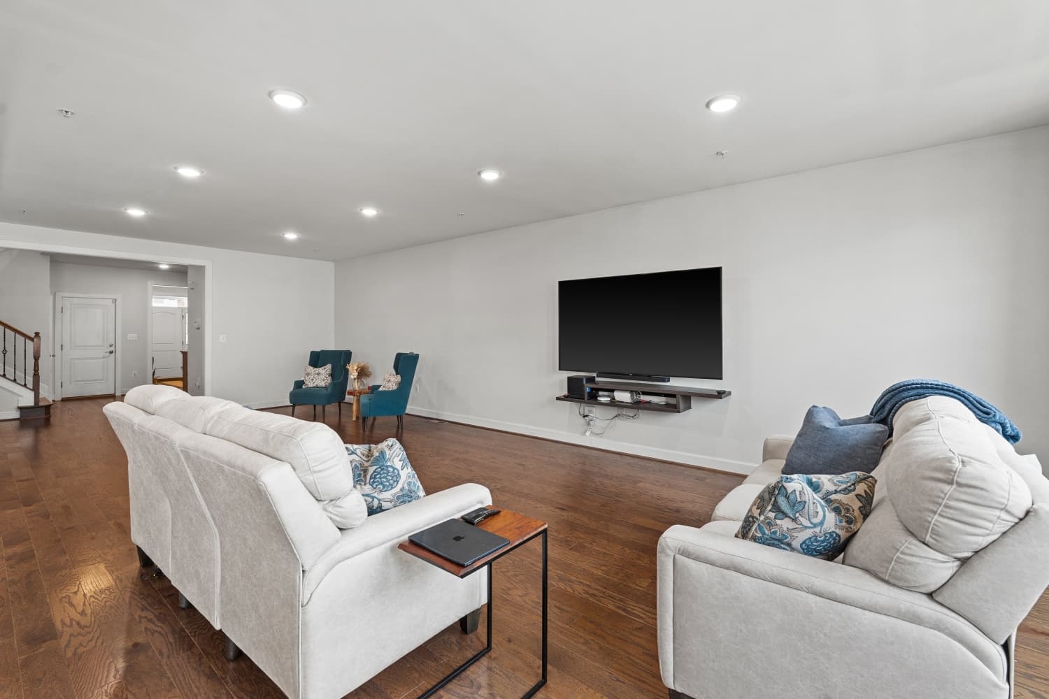 Family room with mounted television and hardwood flooring