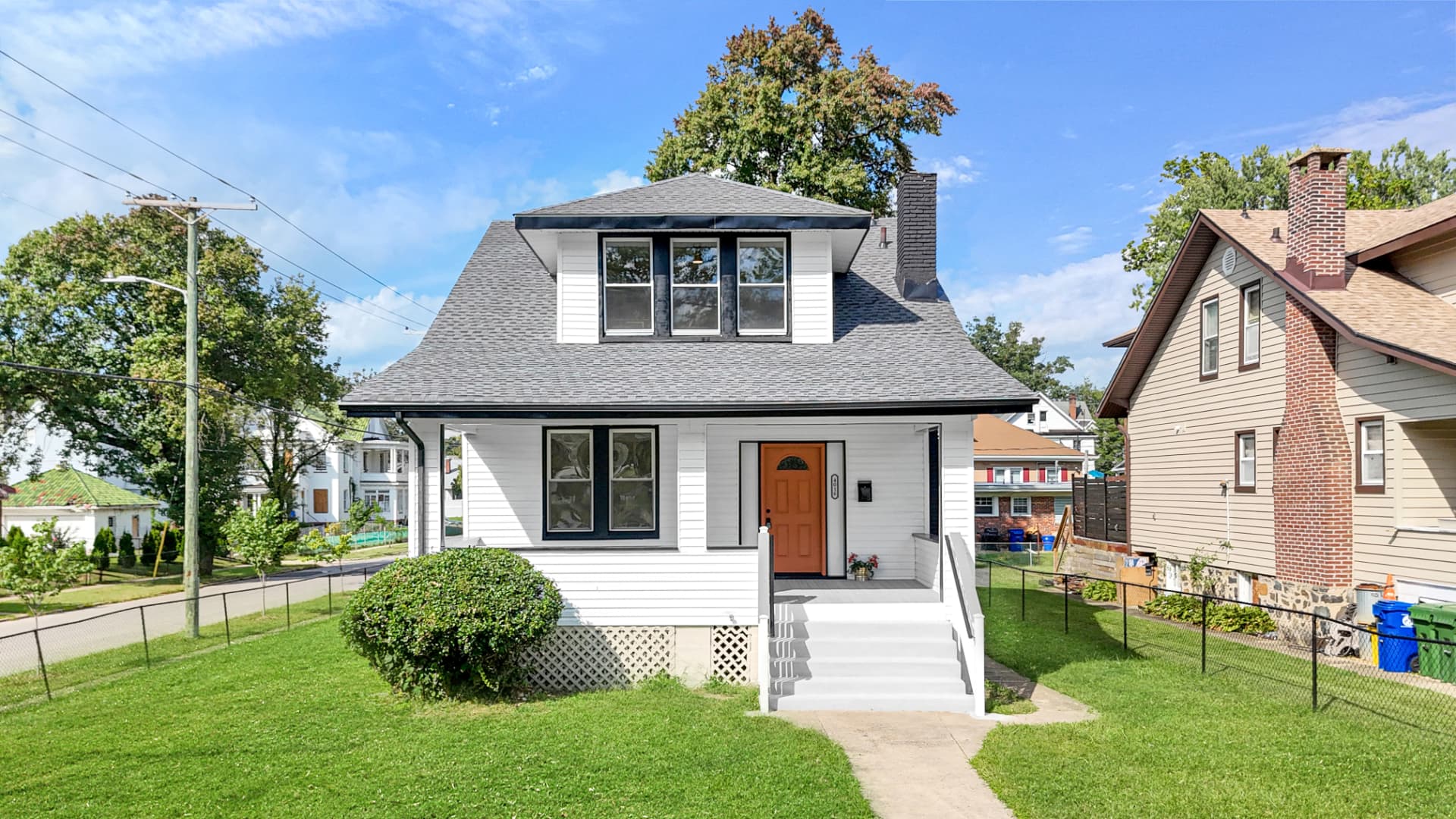4016 Baltimore home — drone front elevation with grey shingle roof and orange front door