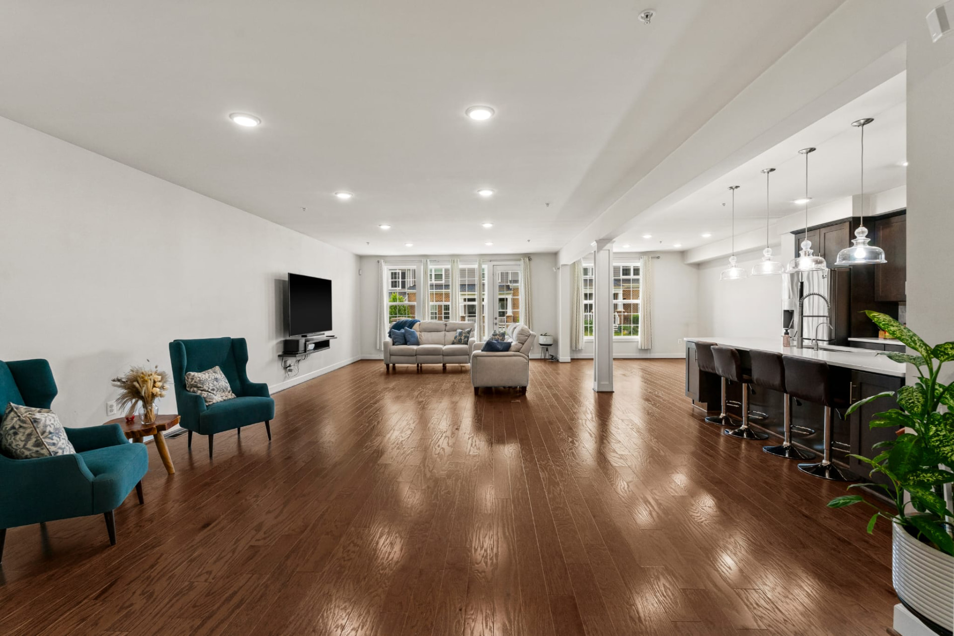 Wide open living space with hardwood floors and a kitchen breakfast bar